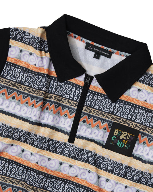 Detail of a black quarter-zip polo shirt with a multi-colored geometric knit print and a woven label.
