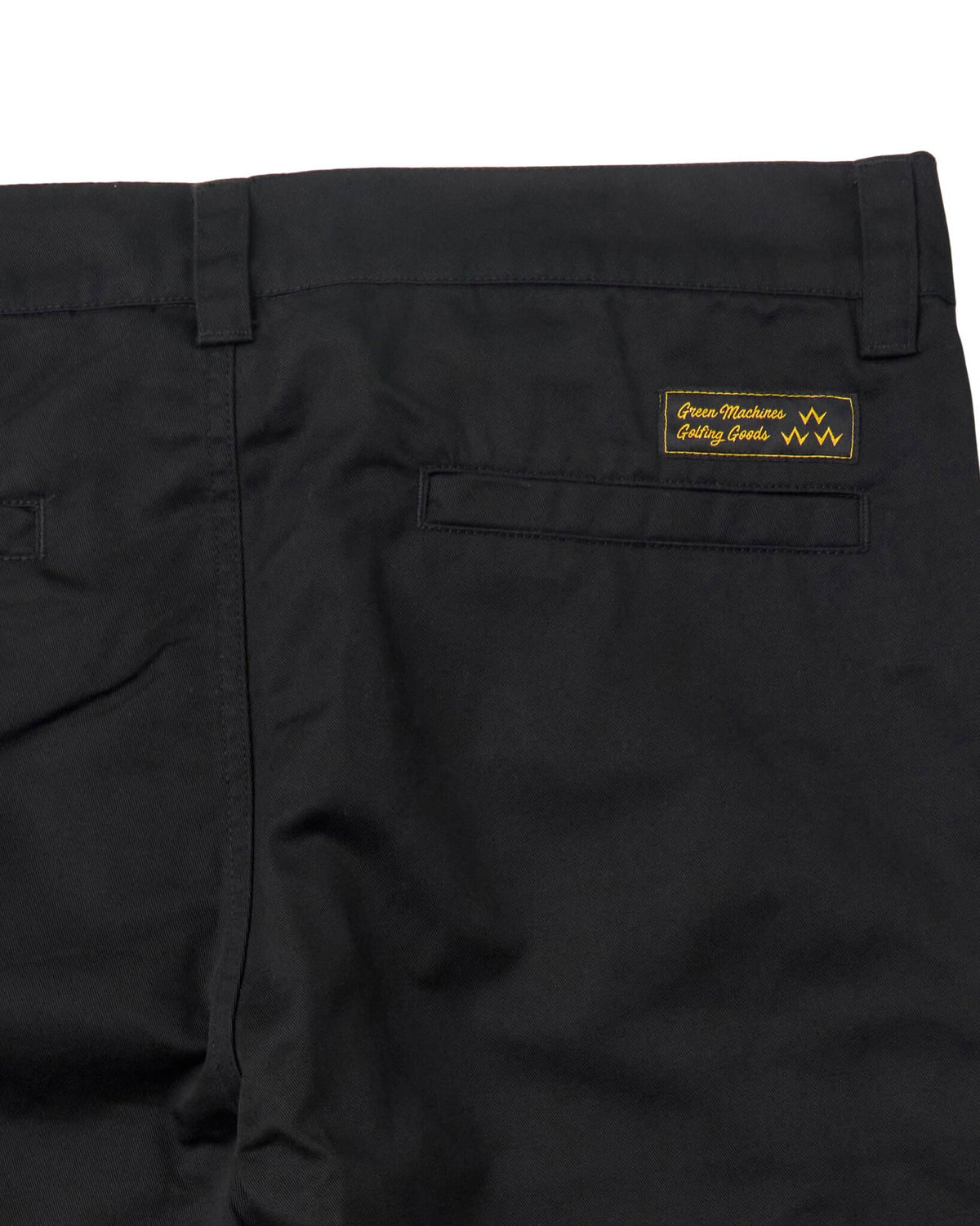Back of black pants with a fixed waistband, belt loops, rear welt pockets, and a rectangular label.