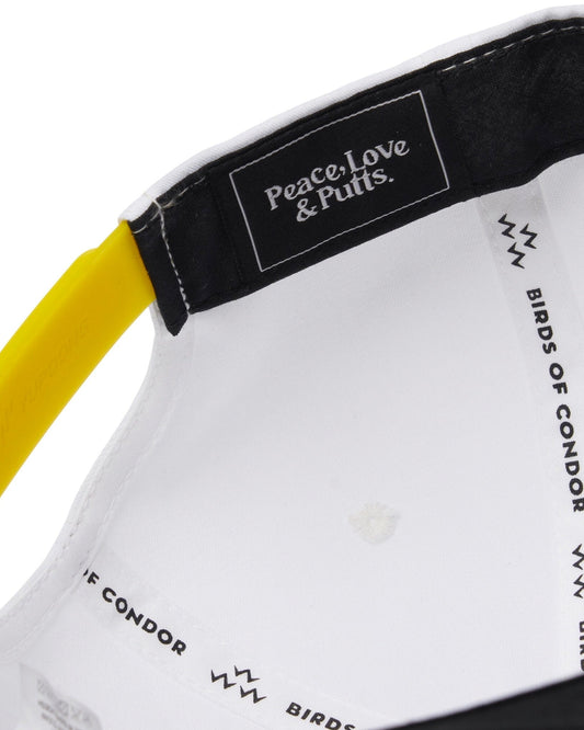 Detail of the white snapback interior showing a yellow strap and text reading Peace, Love & Putts.