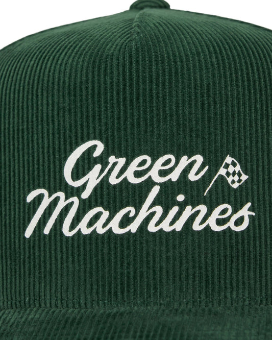 Detail of an alpine green corduroy snapback with a printed white Green Machines script and checkered flag logo.