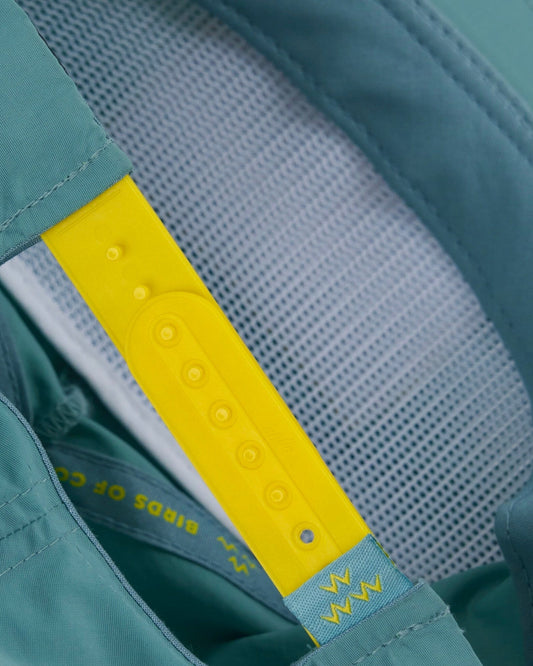 Detail of the mist nylon snapback featuring a contrasting yellow plastic adjustable back strap.