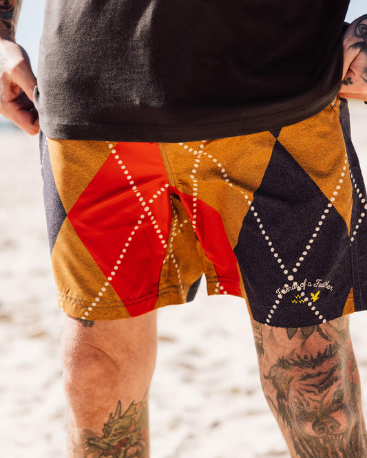 A person wearing argyle walk shorts with printed text and logos on the left leg.