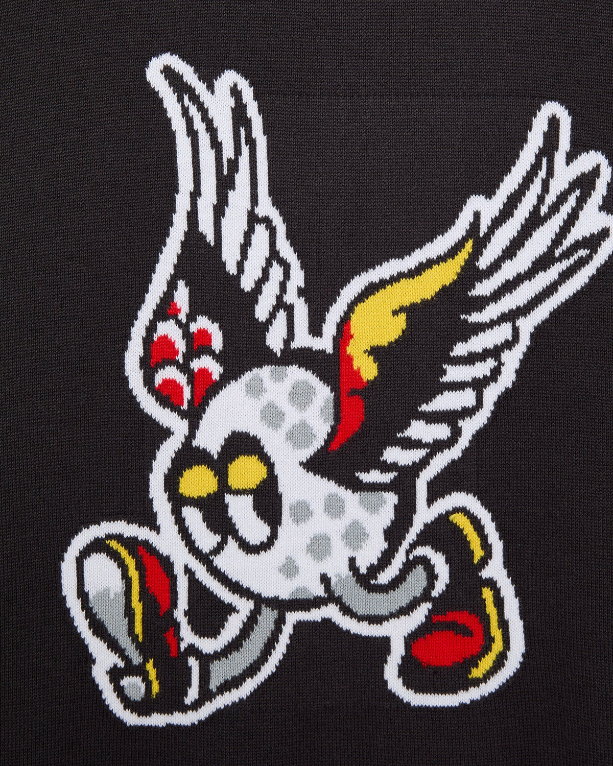 Detail of a black sweater featuring a white winged golf ball graphic with red and yellow wing details.