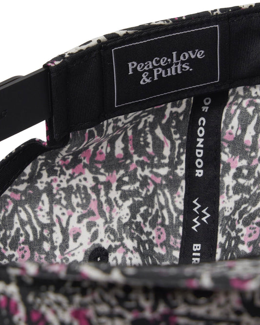 Detail of the inside of a black motley cap showing a pink and white print lining and inner text labels.