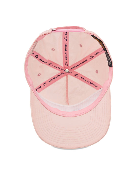 Inside of a faded pink snapback hat showing branded interior seams and a matching sweatband.