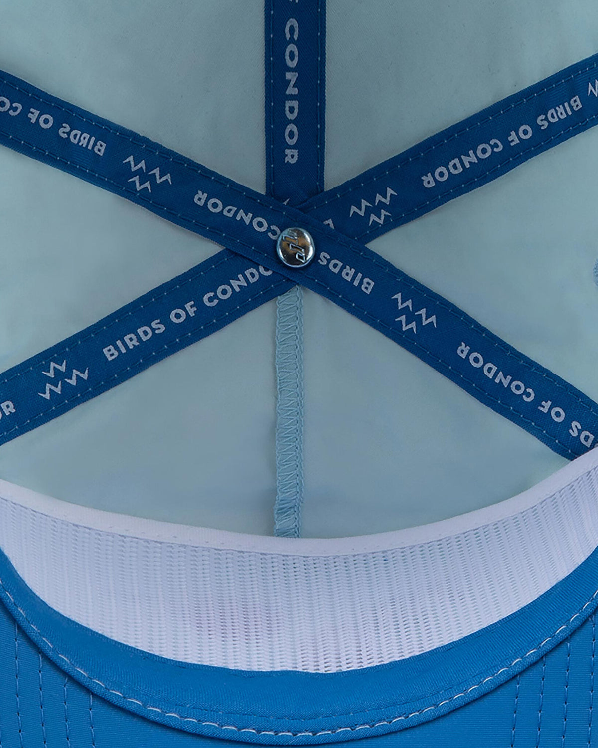 Detail of sky blue cap interior showing blue seam taping printed with white text.