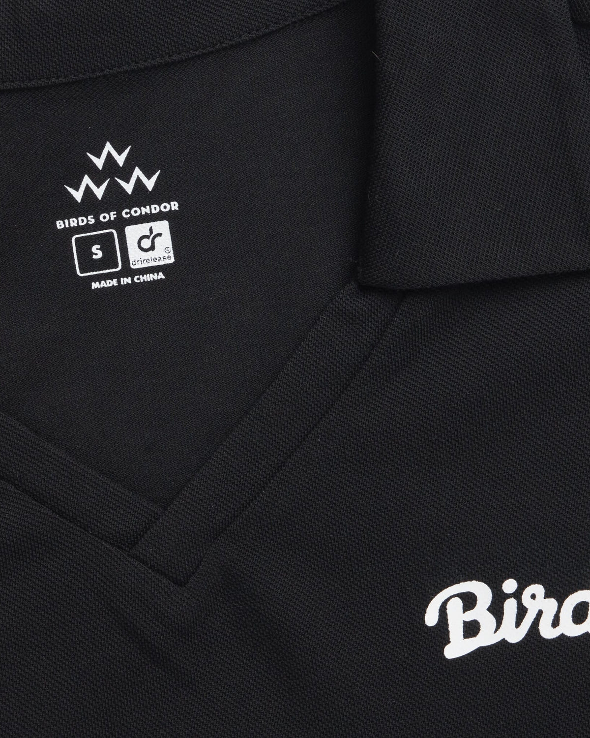 Detail of a black sleeveless polo featuring a V-neck, collar, and a white Birds script graphic.