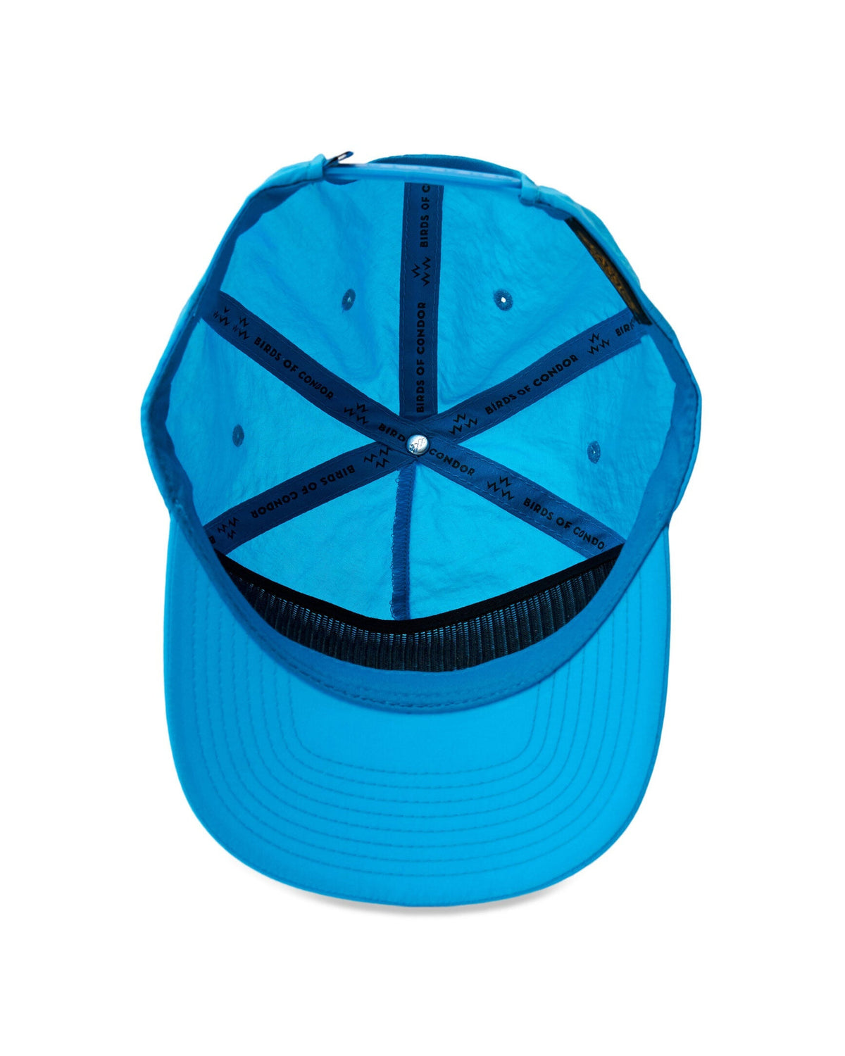 Inside view of an electric blue snapback cap, showing printed interior seams and a black sweatband.