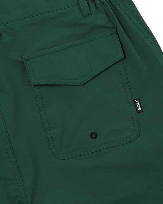Detail of forest green shorts showing a flapped back pocket with a drainage eyelet and small logo tag.