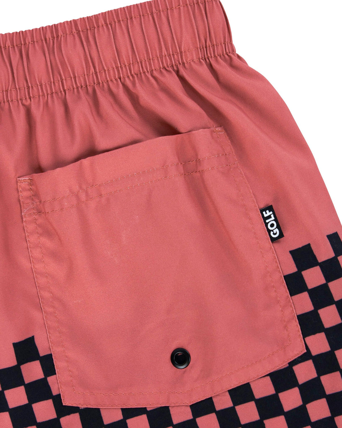 Detail of old rose shorts with a back pocket, elastic waistband, and black checkerboard hem.