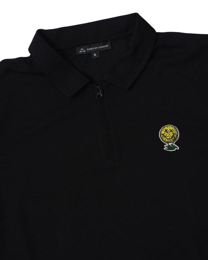 Detail of a black quarter-zip polo shirt featuring an embroidered yellow golf ball smiley face logo.
