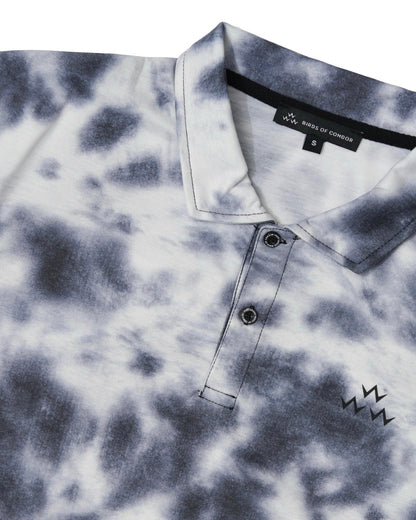 Detail of a black tie-dye polo shirt featuring a two-button placket and a triple eagle print.