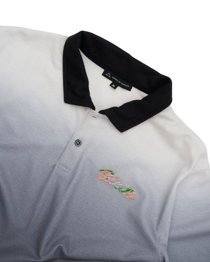 Detail of a black gradient polo shirt featuring a black collar and a colourful printed chest design.