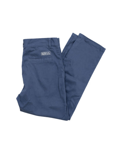 Back of light navy pants featuring a rectangular brand label above the right welt pocket.