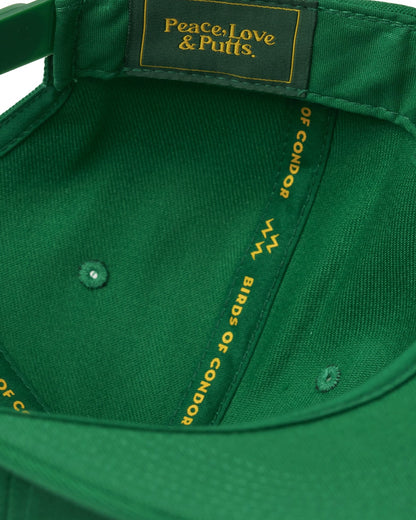 Detail of a green snapback with interior seams featuring a gold text logo and taped text branding.