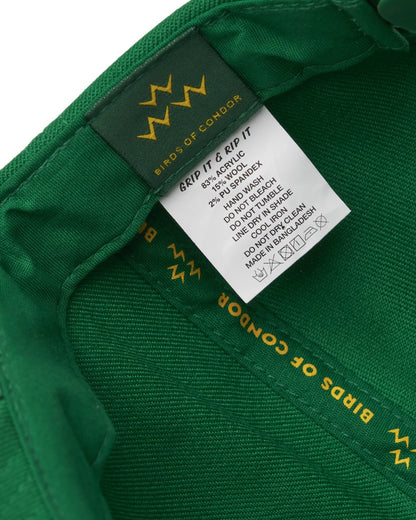 Detail of the interior seams of a Masters green snapback with woven brand taping and care labels.