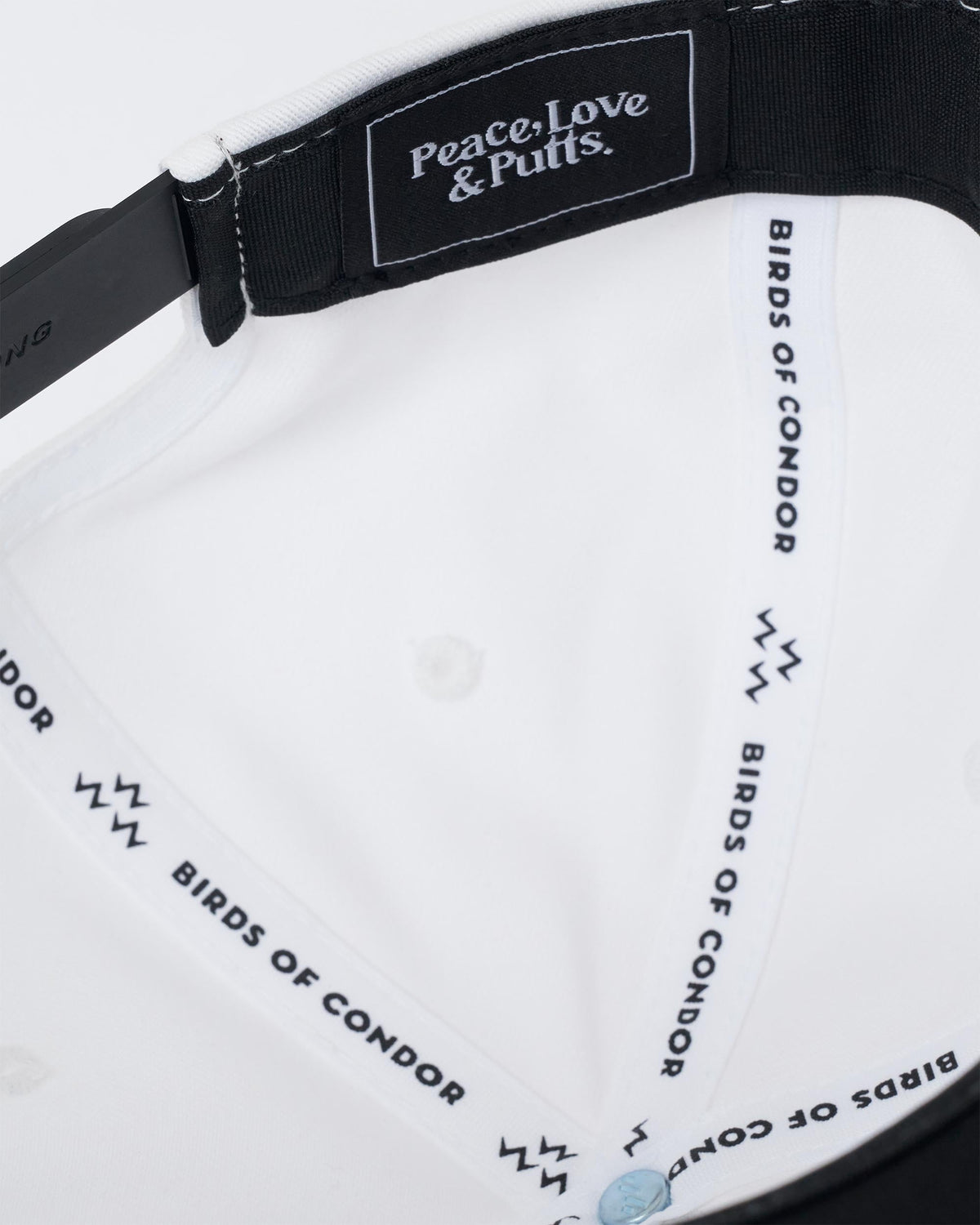 Detail of the white snapback interior showing branded taping and a black label.