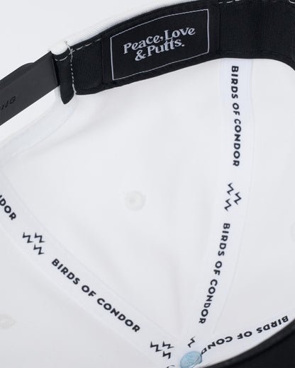 Detail of the white snapback interior showing branded taping and a black label.