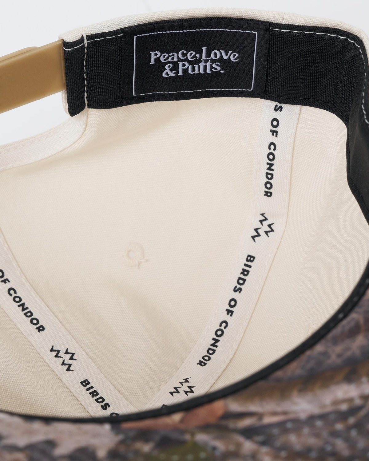Detail of the natural snapback interior, featuring branded inner taping and a woven patch.