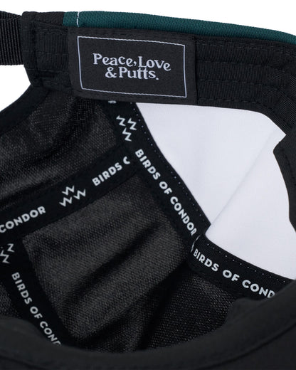 Detail of a white, black, and green cap with interior branded tape reading Peace, Love & Putts.