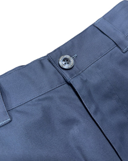 Detail of blue shorts featuring a fixed waistband, belt loops, and a dark button closure.