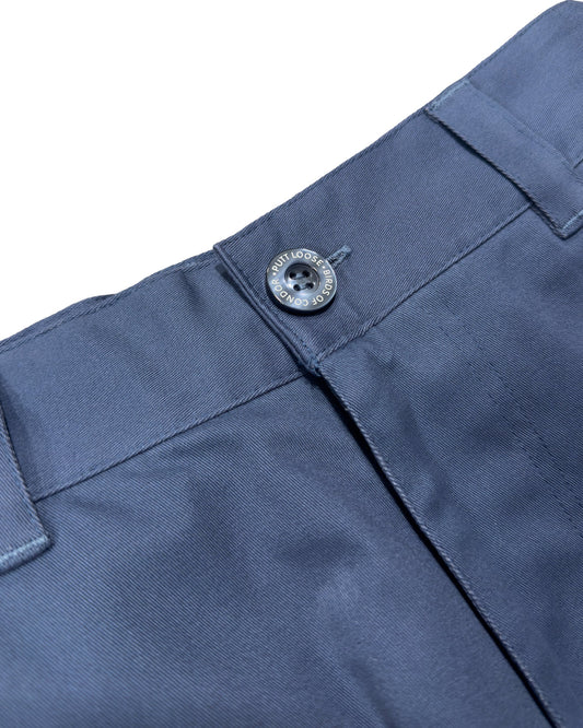 Detail of blue shorts featuring a fixed waistband, belt loops, and a dark button closure.