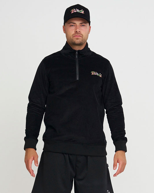 Man wearing a black hoodie and cap with 'Birds' branding on a light gray background