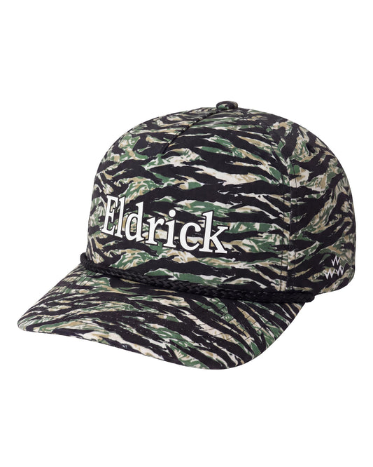 A baseball cap featuring a tiger stripe camouflage pattern in black, green, and beige, with the name 'Eldrick' printed in white across the front.