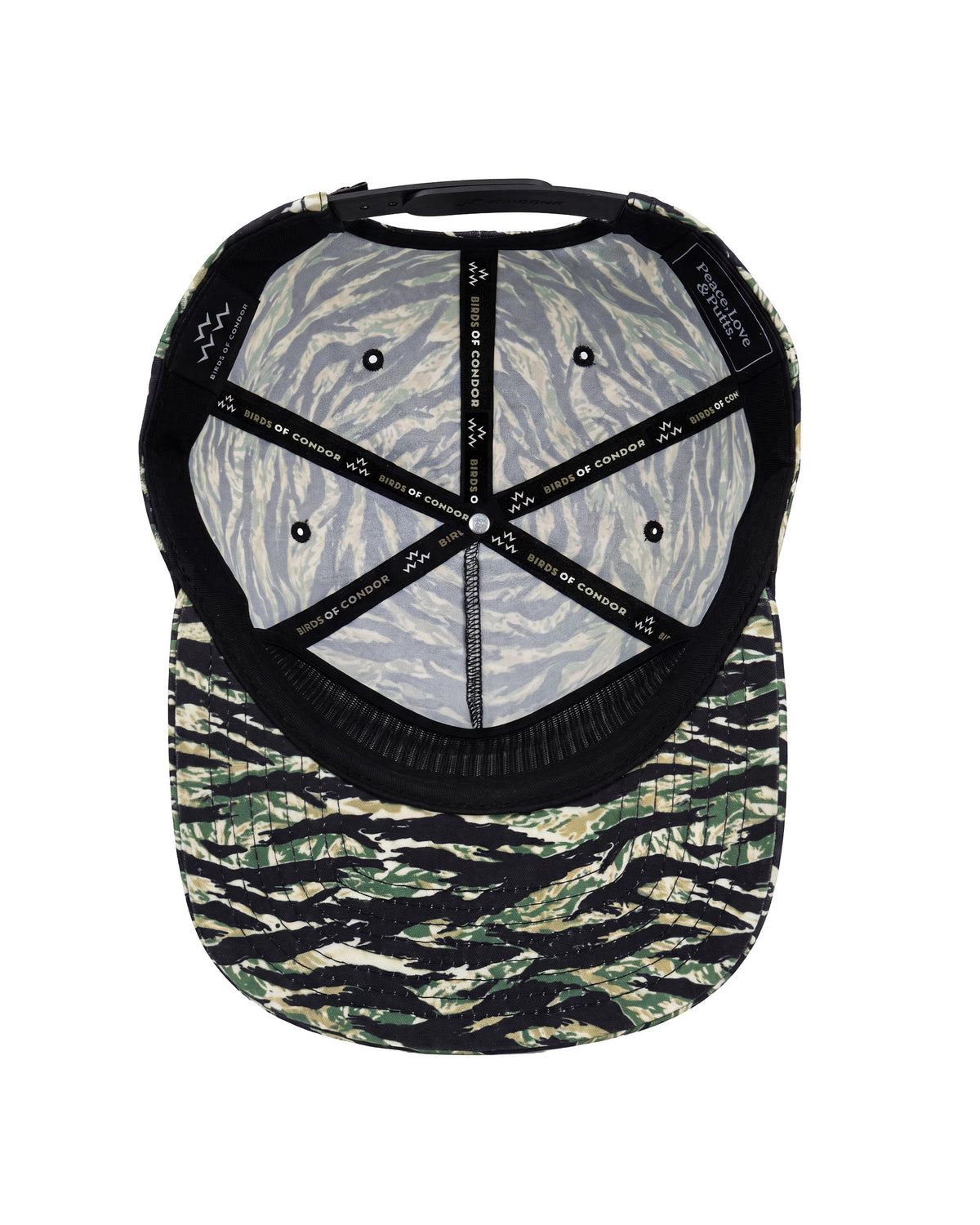 The inside view of a baseball cap featuring a tiger-stripe camouflage pattern on the brim and a gray and black zebra-patterned fabric on the back panels, with black adjustable straps.