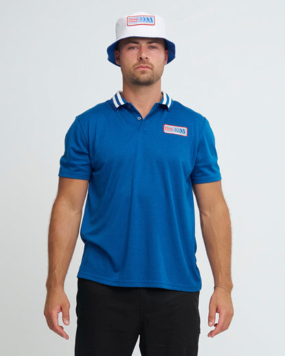 A man wearing a blue polo shirt with a striped white collar and a Swing Kings patch on the left chest.