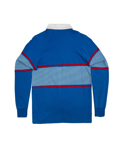 Back of a blue sweater featuring a wide white-striped chest panel bordered by thin red stripes.