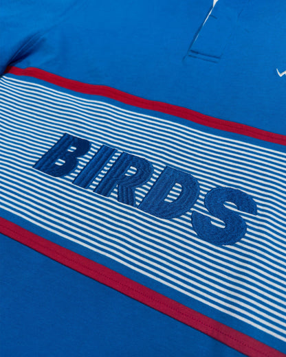 Detail of a blue cotton sweater with a red-trimmed striped chest band and embroidered BIRDS lettering.