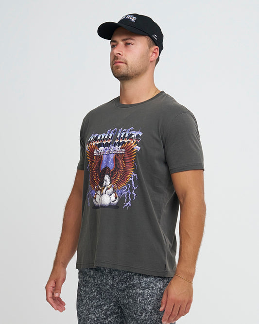 A man wearing denimblack shorts with a black graphic t-shirt and cap.