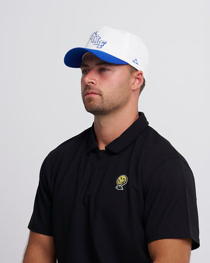 A man wearing a white snapback with a blue brim and a blue golf text design on the front.