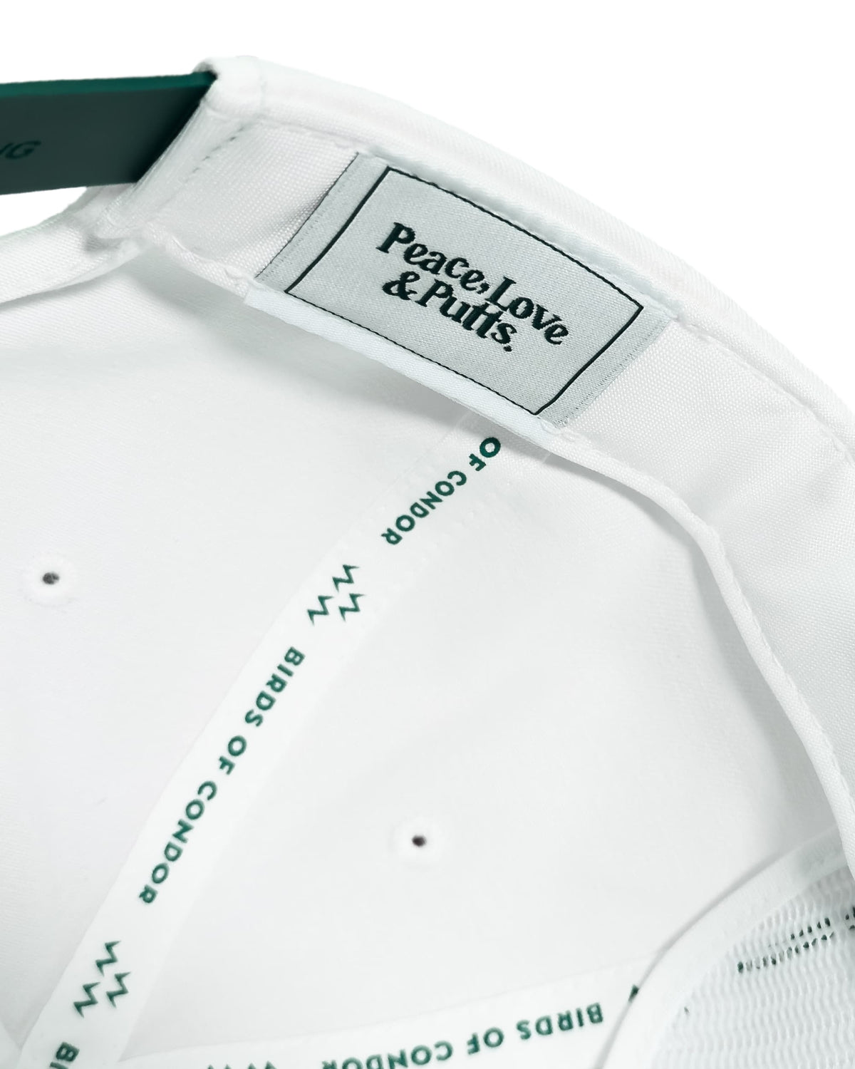 Close-up of a white shirt with 'Peace Love & Putts' label and text on a white background