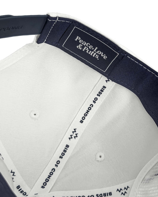 Detail of the inner navy and white snapback cap showing branded taping and an embroidered label.