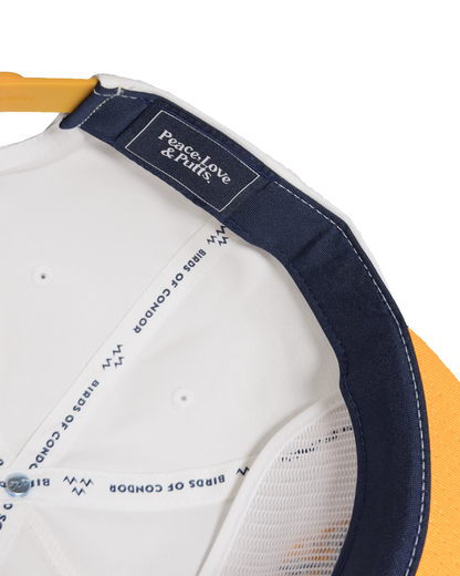 Detail of the white snapback's interior, showing navy inner taping and a black label with white text.