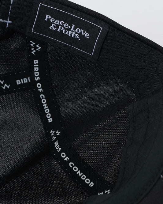Detail of a black sports cap showing interior seam taping and a branded text label inside the crown.