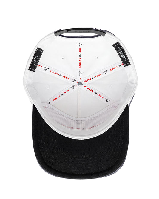 Inside view of white snapback headwear showing interior taped seams and a black brim in a detail shot.