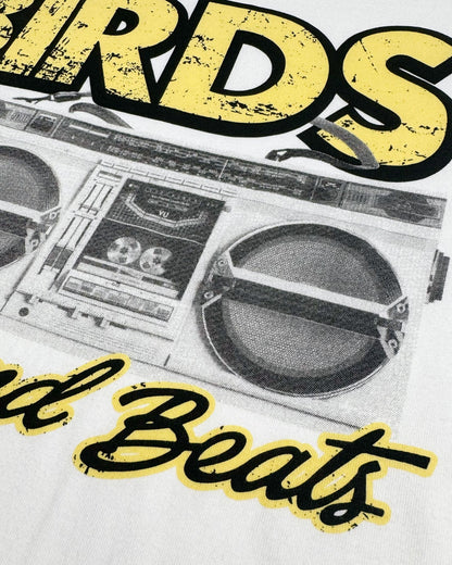 Detail of a white t-shirt featuring a retro graphic of a boombox with yellow and black text.
