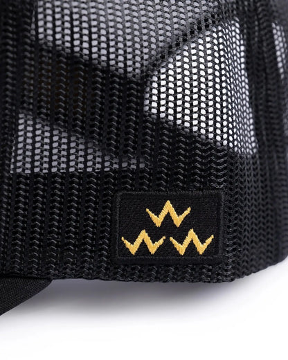 Detail of a black trucker hat mesh back featuring a small rectangular patch with three yellow W's.