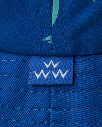 Detail of a blue bucket hat with a small blue tag featuring three white W shapes.
