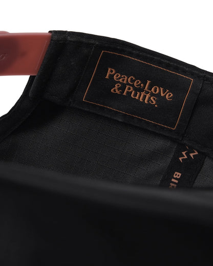 Detail of a black ripstop nylon snapback with an inner label reading Peace, Love & Putts.
