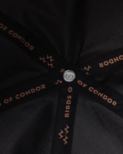 Detail of a black snapback interior featuring branded taping and a metal button.