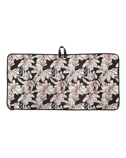 An azalea-coloured waffle texture golf towel with a black and white floral print and a top loop hanger.