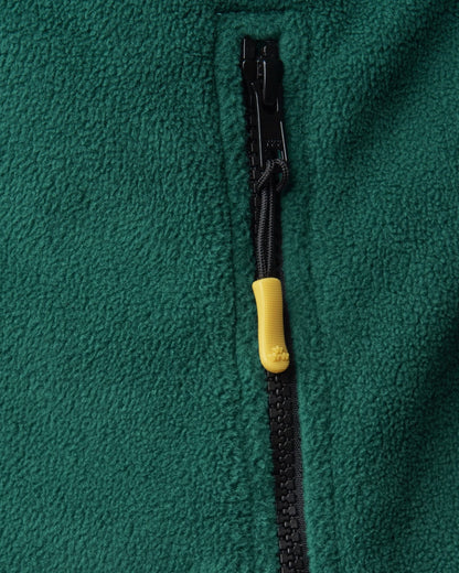 Detail of a green polar fleece sweater with a black zipper and a yellow puller.