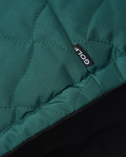 Detail of an amazon green puffer vest with warped argyle quilting and a small GOLF label.