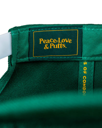 Detail of a green snapback showing a dark green interior label with yellow Peace, Love & Putts text.