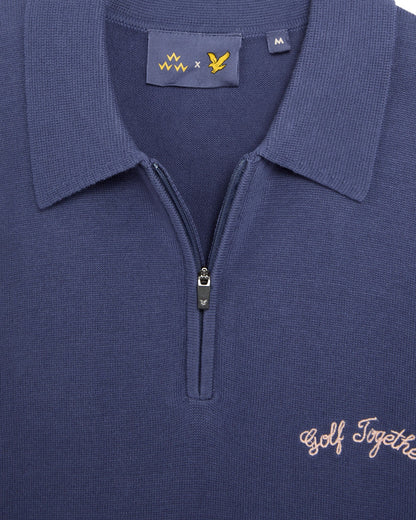 Detail of a crown blue cotton knit polo shirt with a 1/4 zip, collar, and embroidered text.