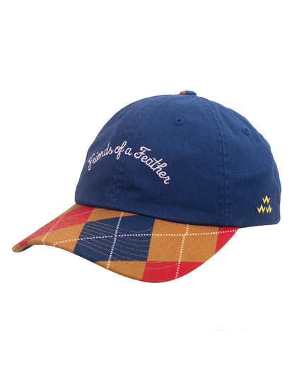 Navy six-panel cap with red argyle brim, white script embroidery on the front, and yellow logo on the side.
